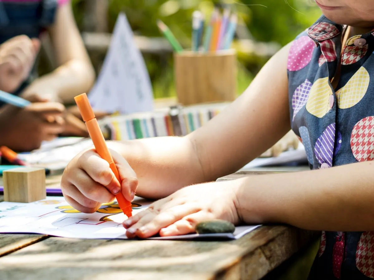 Una niña pinta un dibujo en clase de arte