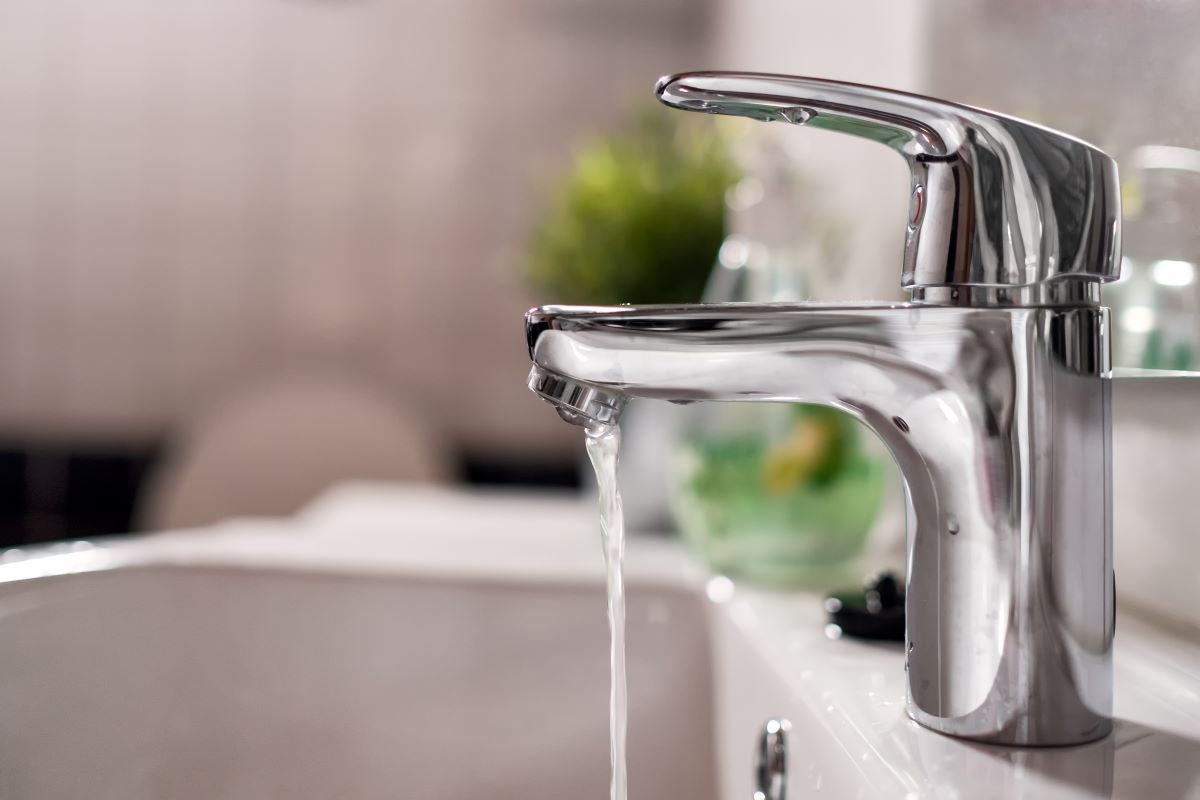 cold-water-flowing-from-faucet-in-clean-bright-bat-2023-11-27-05-28-50-utc