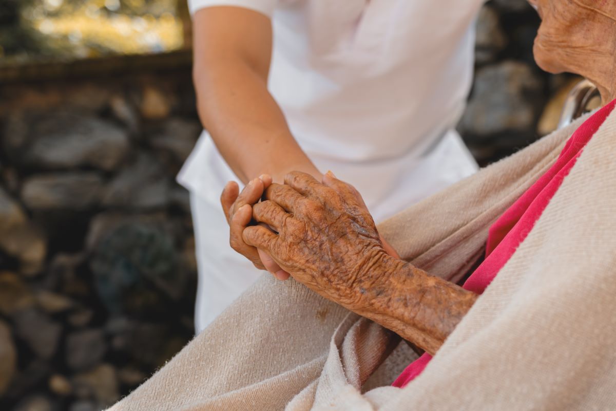 close-up-of-senior-woman-holding-hands-with-caregi-2024-12-07-03-18-12-utc